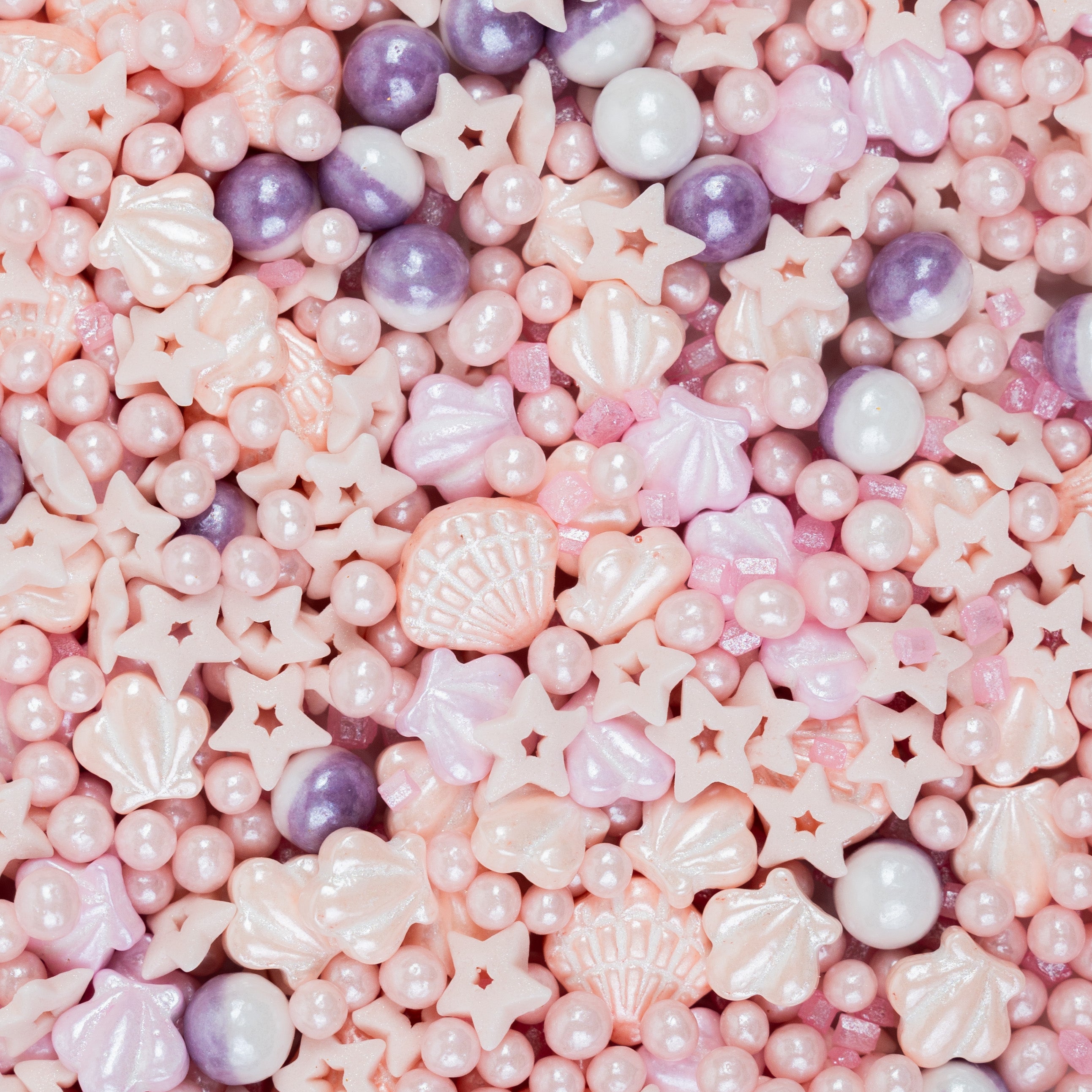 Nahaufnahme des Sallys Streuselwelt Mermaid Pearl Mix mit rosa Muscheln, Perlen, Sternen und lilafarbenen Zuckerstreuseln