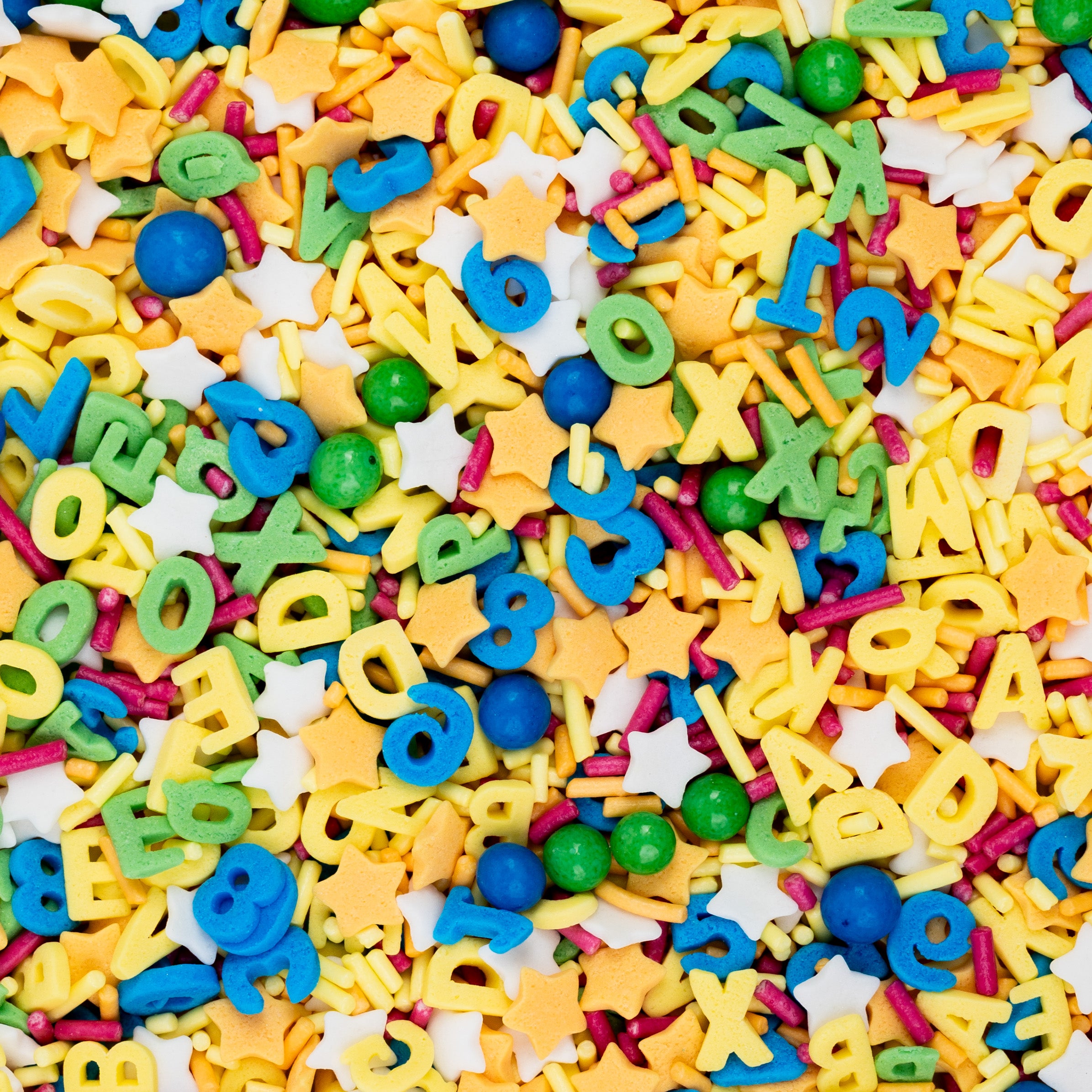 Nahaufnahme des Sallys Streuselwelt ABC Konfetti Mix – bunte Zuckerstreusel in Buchstabenform, Sterne, Kugeln und Sticks in Gelb, Blau, Grün und Pink