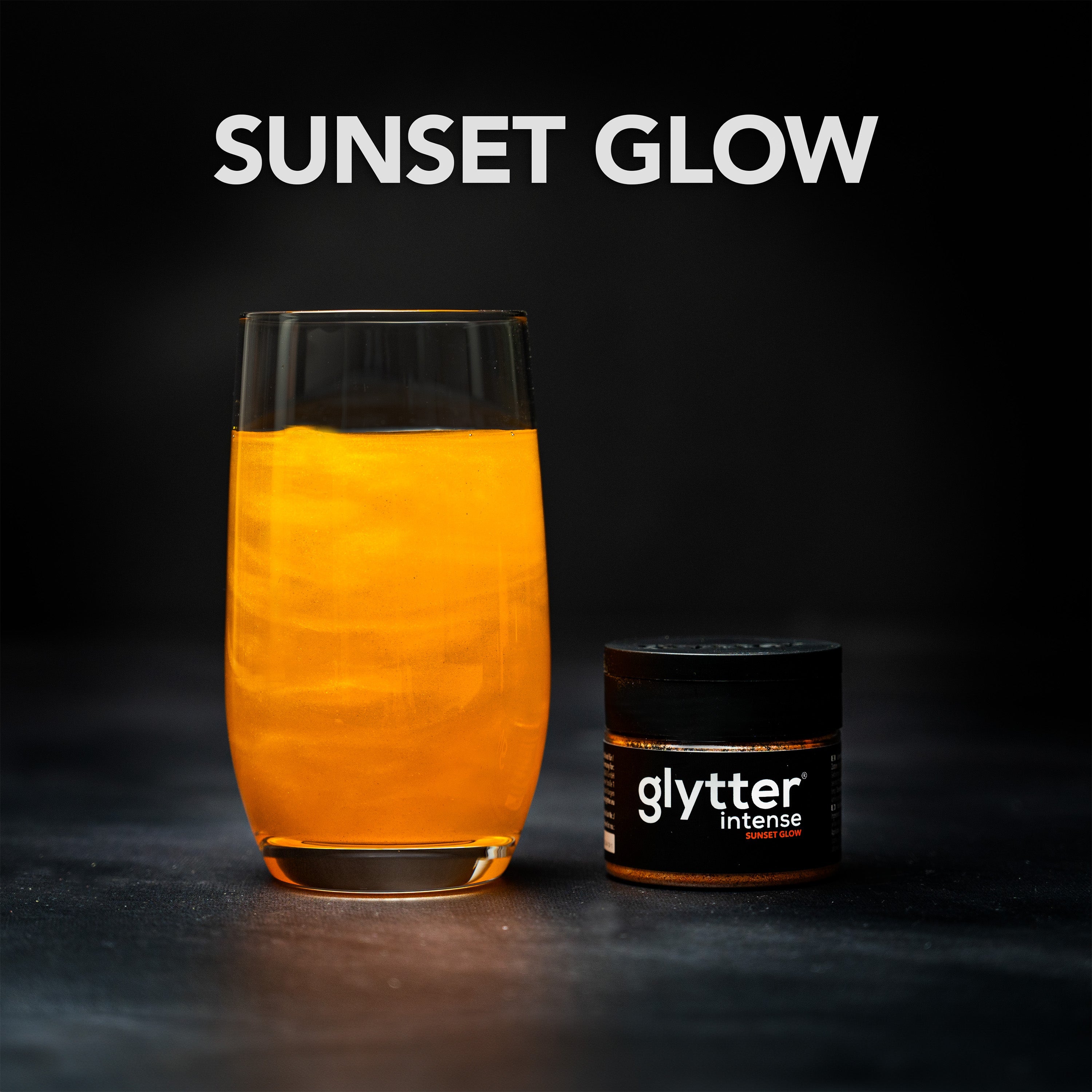 Glytter Intense Sunset Glow – orangefarbenes glitzerndes Getränk im Glas mit Produktdose