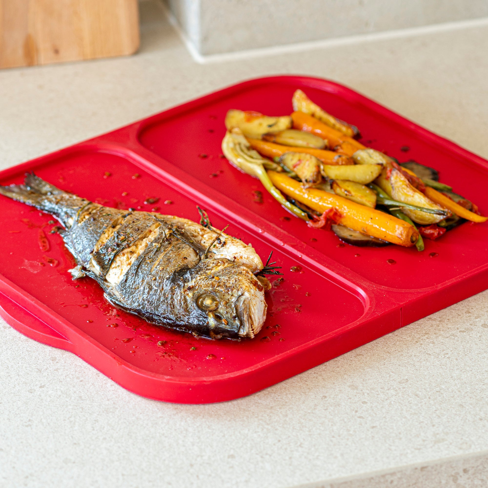 Rechteckiges, rotes Backblech aus flexiblem Silikon mit metallverstärkten, unterteilten Seiten