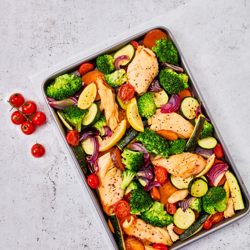 Rechteckiges, silberfarbenes Ofenblech aus Metall mit leicht erhöhtem Rand. Maße: etwa 39,5 x 27 x 2,5 cm. Das Blech ist schlicht, glatt und hat eine Antihaftbeschichtung, frische Zutaten