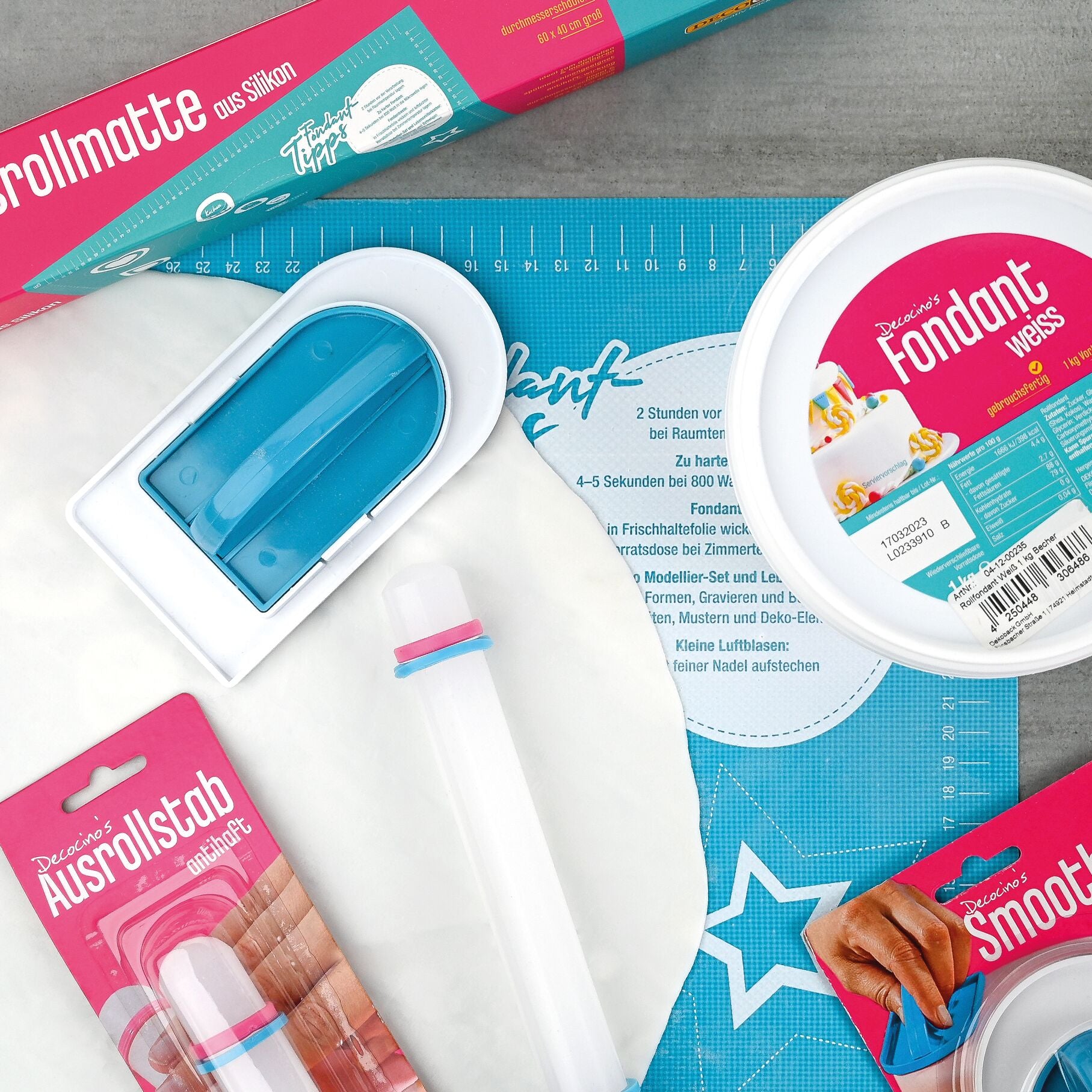 ondant-Set von Decocino mit Ausrollmatte, Ausrollstab, Smoother und weißem Fondant auf einer Arbeitsfläche
