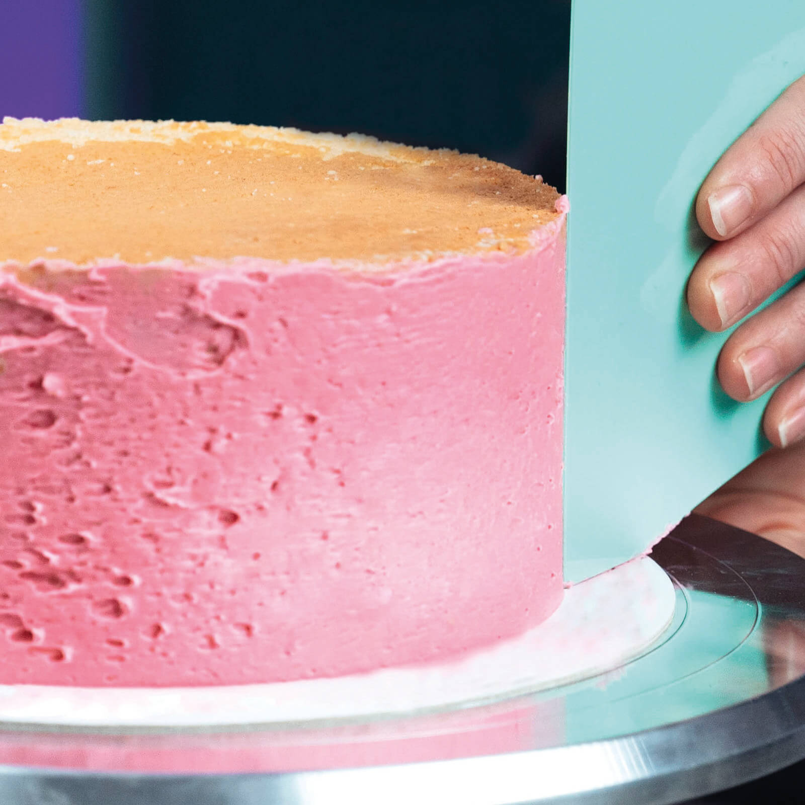 Torte mit rosa Creme wird mit einer mintfarbenen Decocino Teigkarte glattgestrichen – Anwendung des Teigkarten-Sets