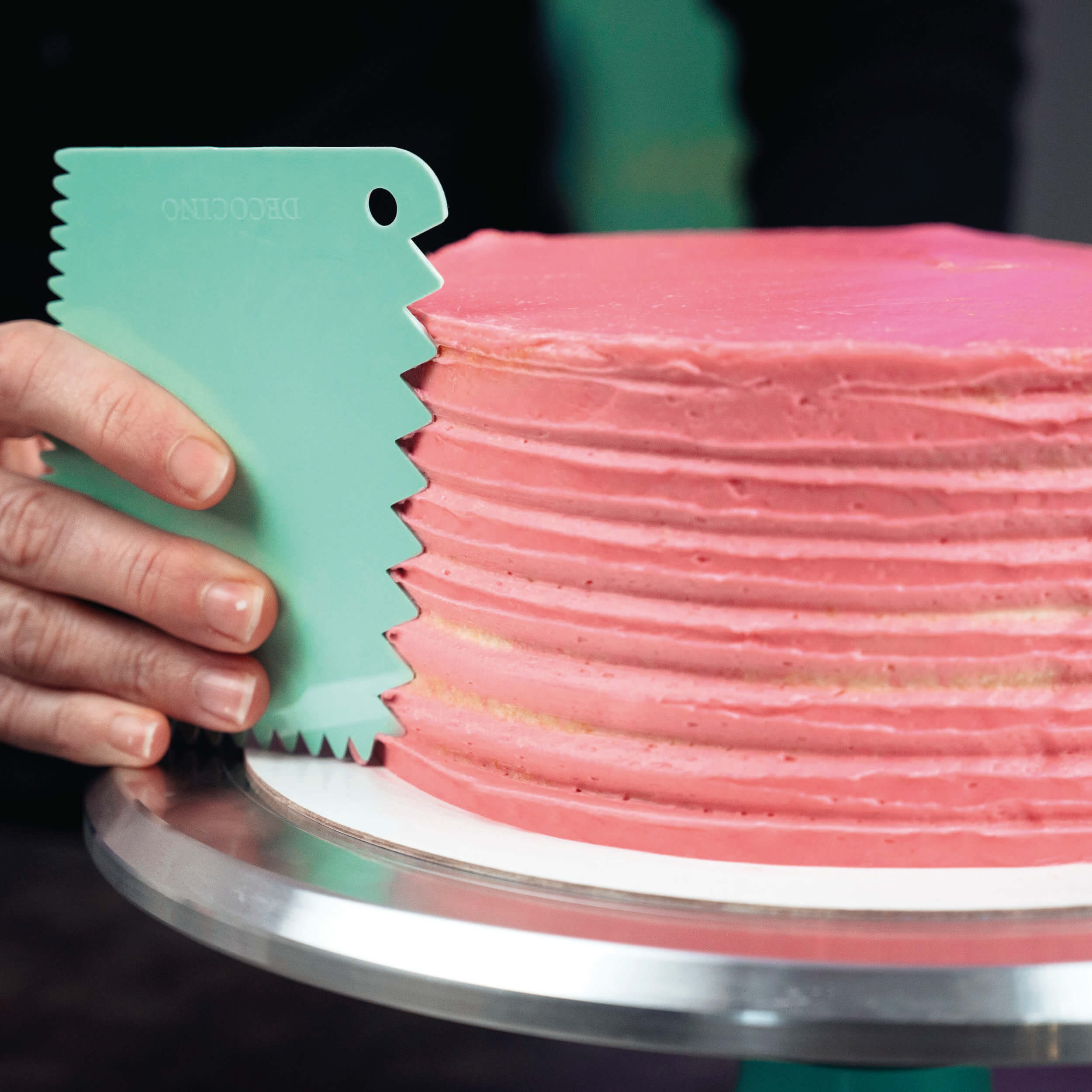 Torte mit rosa Creme wird mit einer mintfarbenen Decocino Teigkarte strukturiert – Verzierung des Tortenrandes